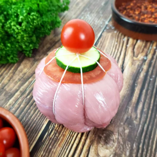 paupiette de veau joliment décorée avec une tomate cerise entourée de persil et d'épice